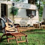 Wenn der Wohnwagen zum zweiten Zuhause wird: Die richtige Matratze fürs Dauercamping Ein fester Platz für die schönste Zeit Dauercamping erfreut sich in Deutschland schon seit einigen Jahren einer stetig wachsenden Beliebtheit: Anstatt jedes Jahr neue Ziele anzusteuern, sichern sich viele Familien einen festen Stellplatz auf einem Campingplatz und verbringen dort regelmäßig Wochenenden, Ferien oder sogar ganze Sommer. Der eigene Wohnwagen wird auf diese Weise zu einem zweiten, kleinen Zuhause, das ganzjährig fest an Ort und Stelle bleibt. Genau dieser dauerhafte Einsatz stellt allerdings andere Anforderungen an die Ausstattung als ein gelegentlicher Kurztrip, besonders wenn es um die passende Matratze für den festen Stellplatz geht. Andere Anforderungen als beim Kurztrip Während ein Wohnwagen, der nur wenige Wochenenden im Jahr genutzt wird, mit einer einfacheren Liegefläche auskommt, zeigt sich bei dauerhaftem Stellplatzbetrieb schnell ein anderes Bild. Der Wagen steht über Monate hinweg auf demselben Untergrund und ist Temperaturschwankungen zwischen kühlen Nächten und warmen Tagen ausgesetzt. Er wird insgesamt deutlich häufiger und intensiver genutzt als auf einer klassischen Rundreise mit dem Camper. Diese dauerhafte Beanspruchung stellt ganz besondere Ansprüche an Material, Belüftung und Langlebigkeit der eingesetzten Matratze. Feuchtigkeit als zentrales Thema Ein zentrales Thema beim Dauercamping ist die Feuchtigkeitsregulierung. Wohnwagen sind in der Regel deutlich schlechter isoliert als feste Gebäude, wodurch sich gerade an kühlen Tagen leichter Kondenswasser bilden kann, gerade an Stellen, an denen die Matratze direkten Kontakt zur Wand oder zum Boden hat. Eine hochwertige Wohnwagen Matratze mit atmungsaktivem, offenporigem Schaumstoff und einem robusten, gleichzeitig luftdurchlässigen Bezug beugt Schimmelbildung wirksam vor und sorgt dafür, dass die Liegefläche auch nach feuchten Nächten zügig wieder abtrocknet. Ungewöhnliche Grundrisse ausnutzen Auch die Größe verdient beim Dauercamping besondere Aufmerksamkeit, denn Wohnwagen bringen oft ungewöhnliche Grundrisse mit sich. Abgeschrägte Ecken am Bug, integrierte Staufächer unter der Liegefläche oder asymmetrische Betten sind alles andere als selten und lassen sich mit reinen Standardmaßen aus dem Möbelhaus nur selten wirklich zufriedenstellend lösen. Eine passgenau nach den eigenen Maßen gefertigte Lösung schließt solche Lücken vollständig, was nicht nur den Schlafkomfort spürbar erhöht, sondern auch zuverlässig verhindert, dass Kleinteile oder Zubehör in schwer erreichbaren Zwischenräumen verschwinden. Langlebigkeit über viele Saisons Da der Wohnwagen beim Dauercamping oft über Jahre am gleichen Platz steht, lohnt sich außerdem der Blick auf die Langlebigkeit der verwendeten Materialien. Ein hochwertiger Kaltschaum mit ausreichender Rohdichte behält seine stützende Wirkung zuverlässig auch nach jahrelanger, regelmäßiger Nutzung, während deutlich günstigere Schaumstoffe spürbar schneller durchliegen und mit der Zeit an Komfort verlieren. Wer über mehrere Saisons hinweg gut schlafen möchte, sollte deshalb nicht am Material sparen, sondern gezielt in eine Ausführung investieren, die für den Dauereinsatz gemacht ist. Der passende Härtegrad für zwei Auch der individuelle Härtegrad bleibt beim stationären Wohnwagen ein wichtiges Thema, denn anders als bei einer kurzen Reise wird hier über viele Wochen im Jahr geschlafen. Wer zu zweit auf dem eigenen Stellplatz lebt, profitiert spürbar davon, den Härtegrad individuell an das eigene Körpergewicht anzupassen oder sogar zwei unterschiedliche Zonen in einer einzigen Matratze zu kombinieren, damit beide Partner gleichermaßen gut schlafen, ganz unabhängig von individuellen Vorlieben, Gewicht und persönlichen Bedürfnissen. Ein echtes Zuhause auf Zeit Wer all diese Punkte beim Kauf sorgfältig berücksichtigt, sichert sich langfristigen und verlässlichen Schlafkomfort auf dem eigenen Stellplatz, Saison für Saison aufs Neue. Eine durchdacht ausgewählte Matratze macht den Unterschied zwischen einem Wohnwagen, der sich wie ein bloßes Provisorium anfühlt, und einem echten zweiten Zuhause. In diesem kann sich die ganze Familie Saison für Saison über Jahre hinweg richtig wohlfühlen.